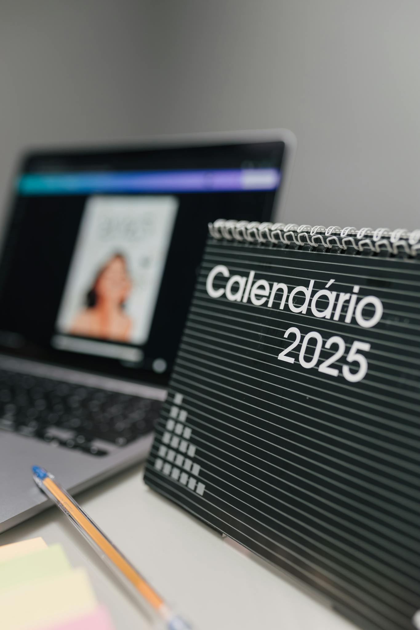 Close-up of 2025 desk calendar and laptop, ideal for office themes.